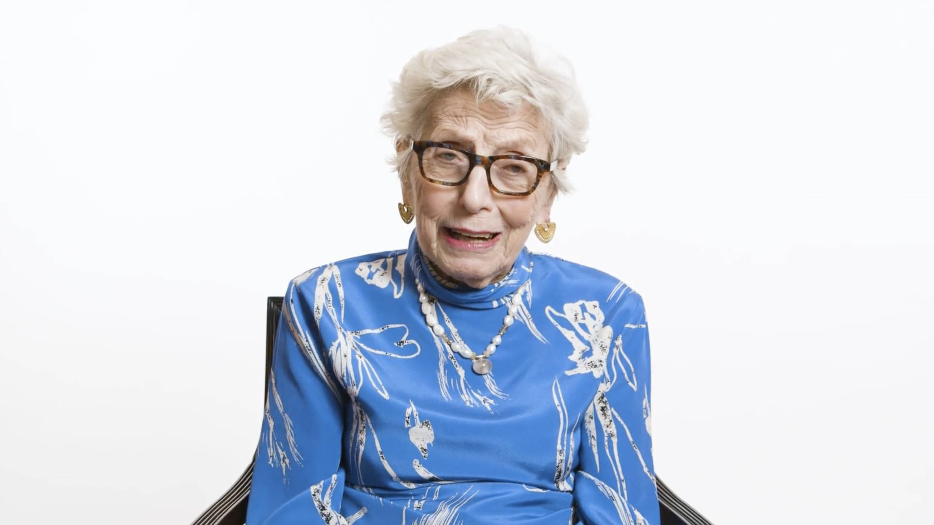 Smuk ældre kvinde blå ovenpå et glansfuldt orange Wallpaper