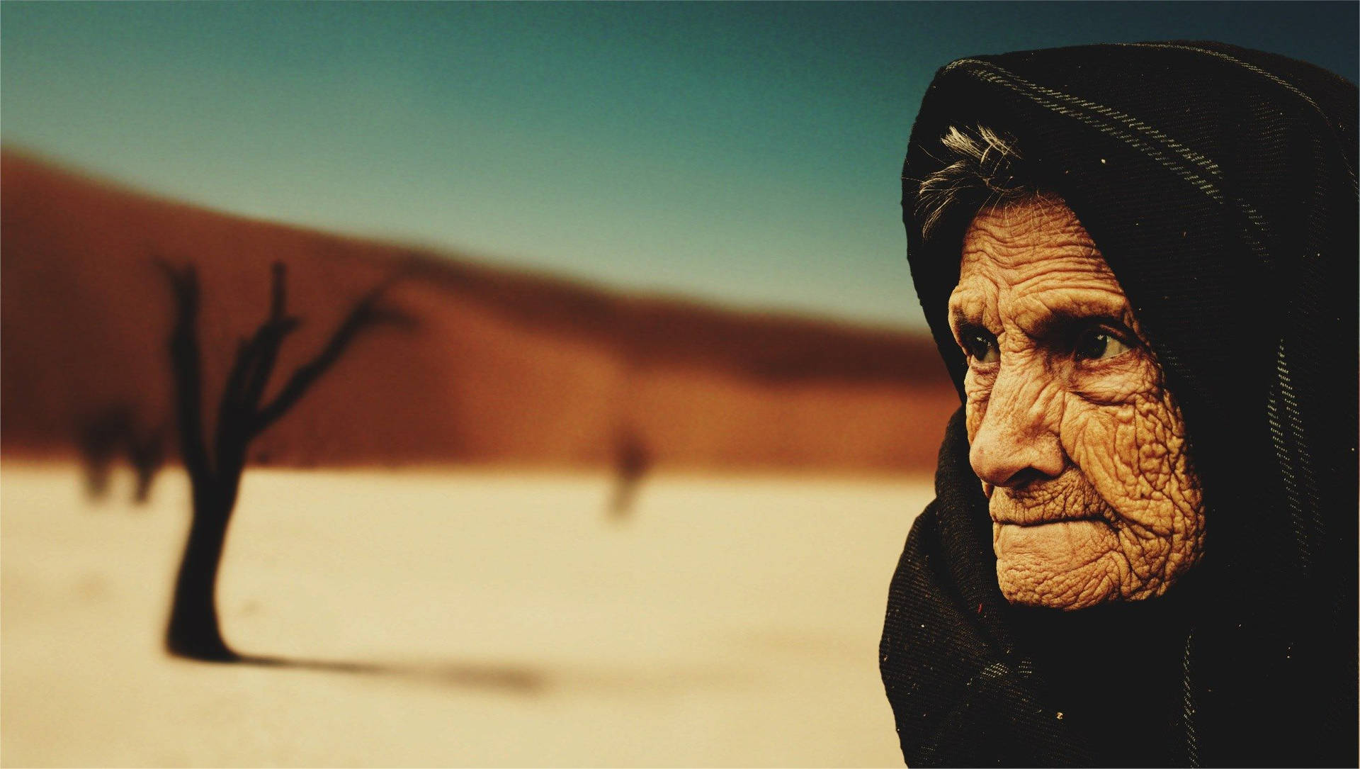 Hübscheältere Frau In Der Wüste Wallpaper