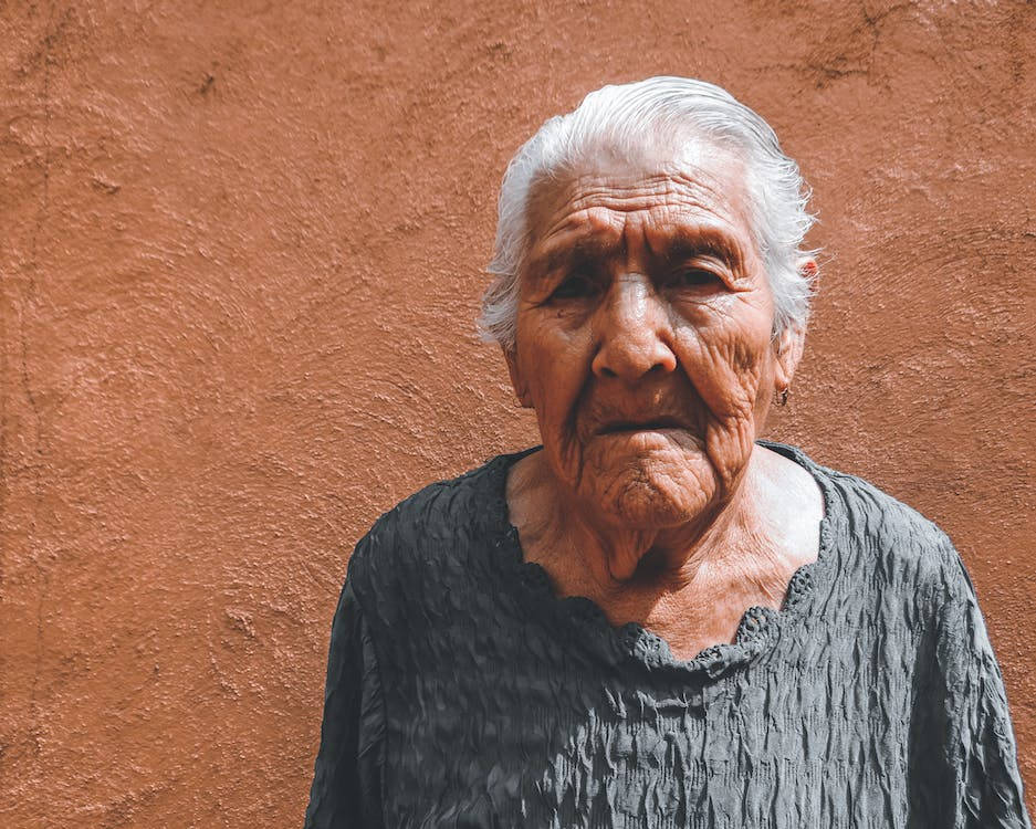 Smuk ældre kvinde på brune baggrund Wallpaper