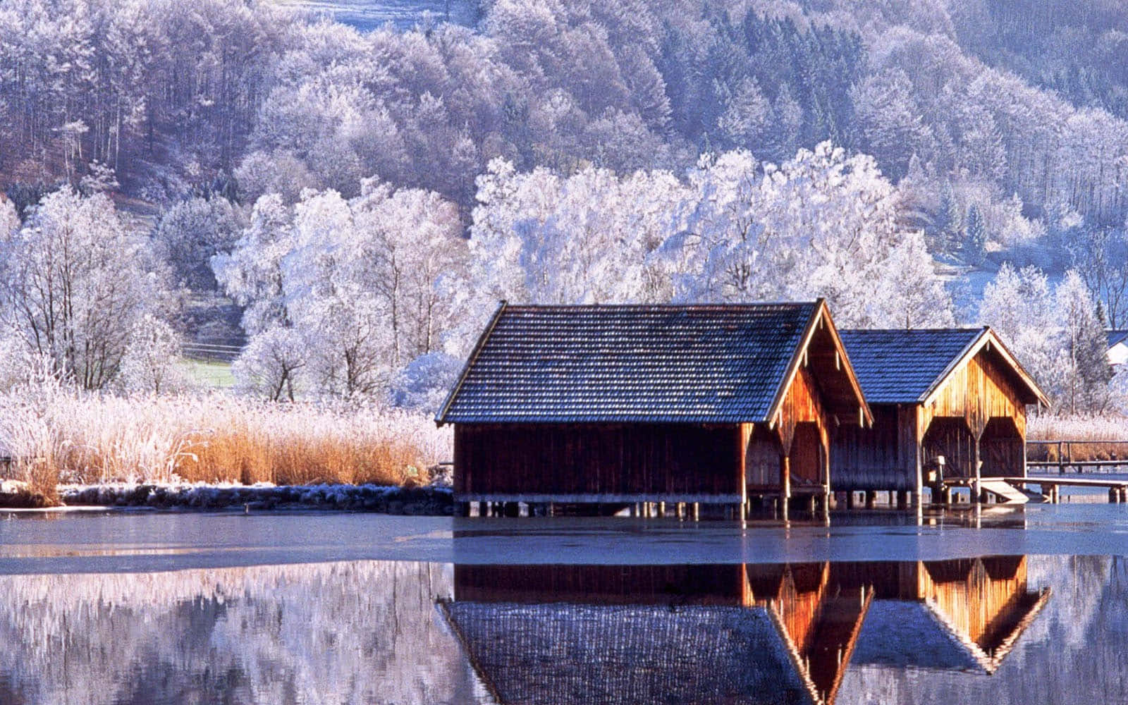 Two Wooden Cabins On A Frozen Lake