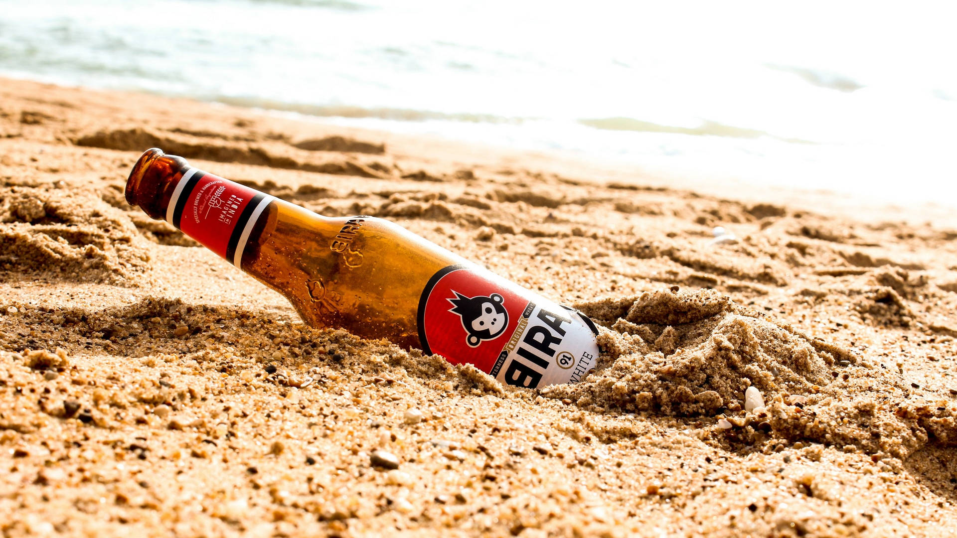 Beer Bottle Buried On The Sand Wallpaper