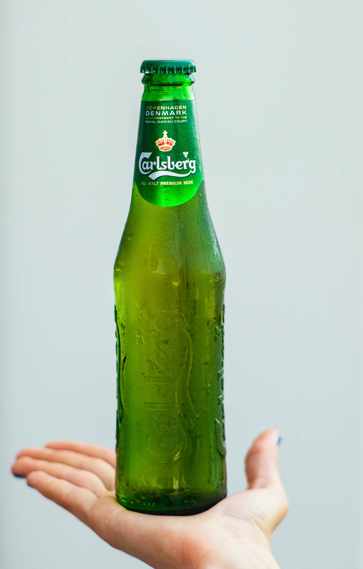 En flaske Carlsberg øl dryppende i et glas. Wallpaper