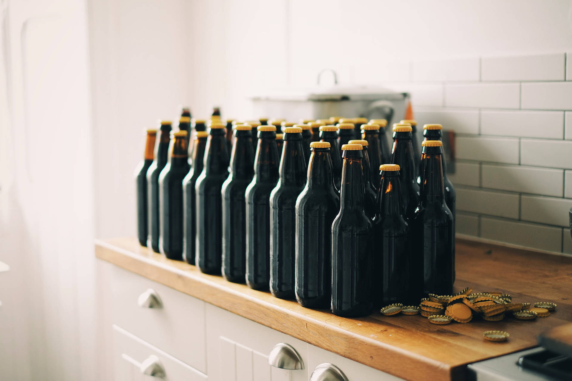 Caption: Chilled Beer Bottles with Yellow Crowns Wallpaper