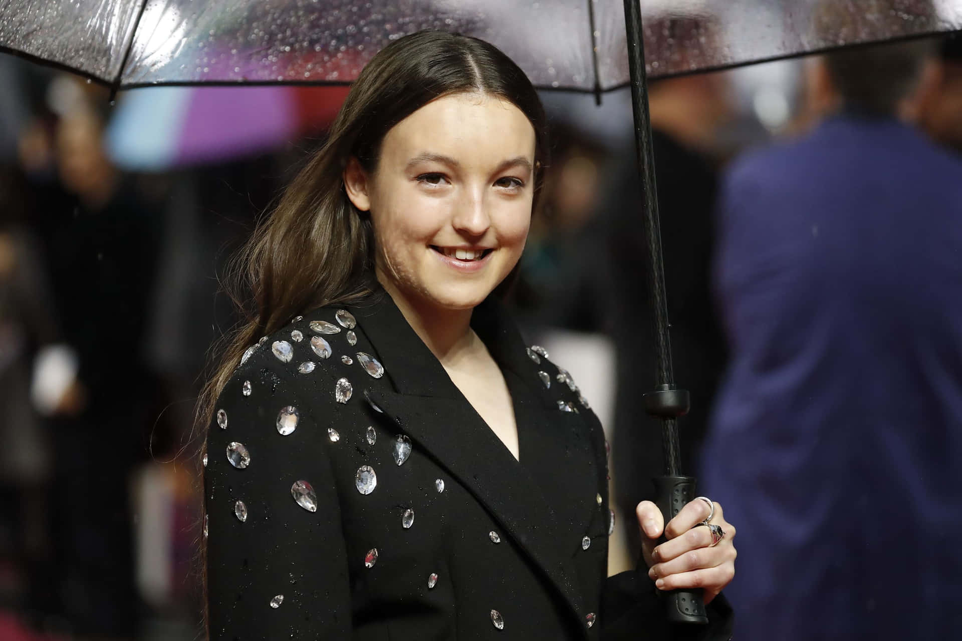 Bella Ramsey Smiling With Umbrella Wallpaper