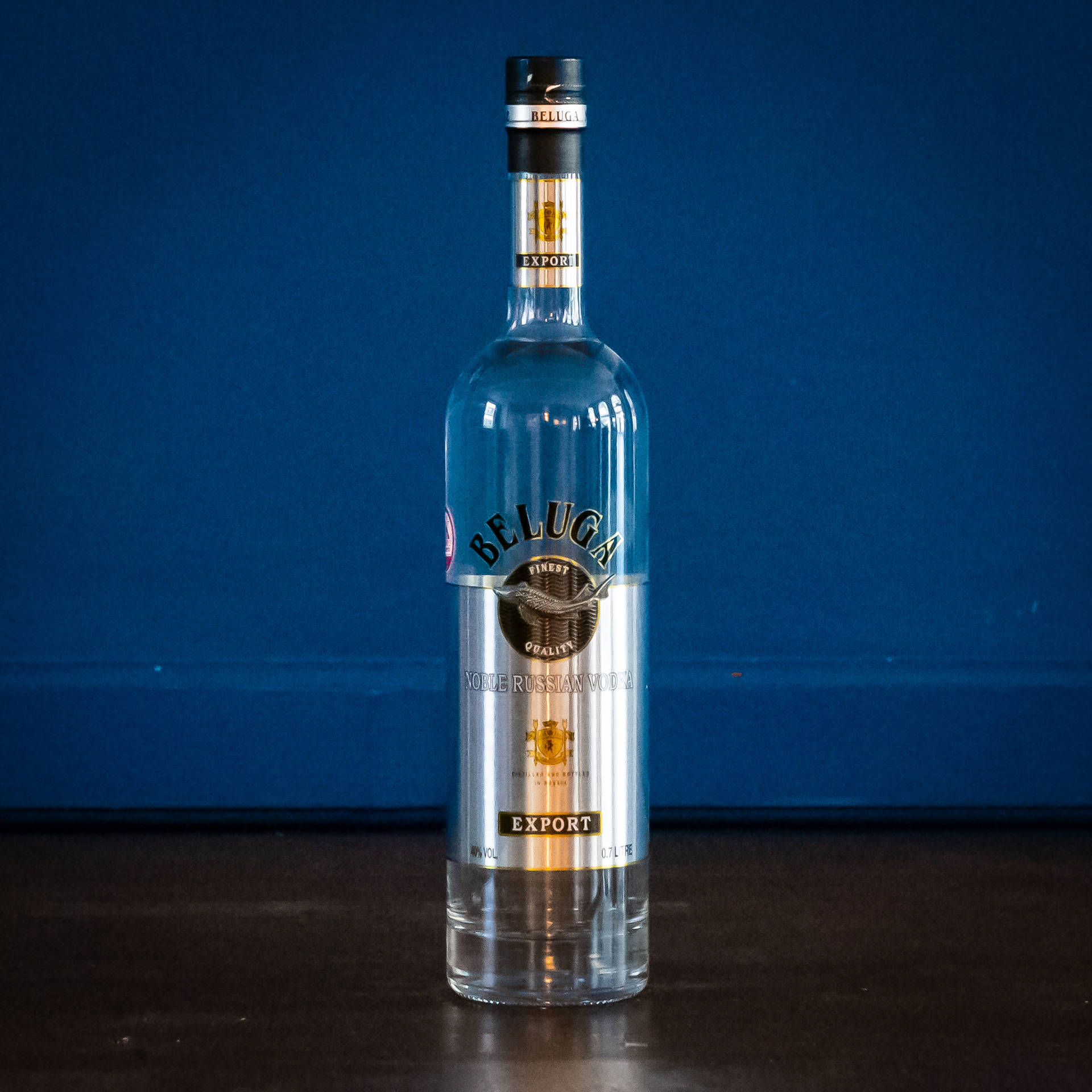 Beluga Vodka Glass Bottle On Blue Backdrop Wallpaper