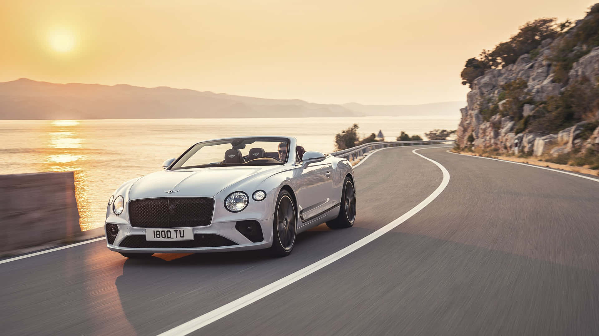 The Bentley Continental Gt - V Driving Down A Road