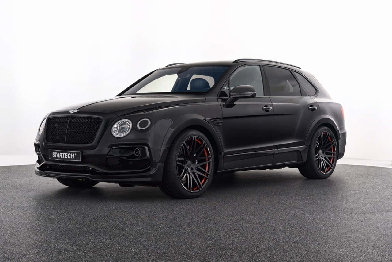 Luxurious Bentley Bentayga cruising on a scenic route Wallpaper