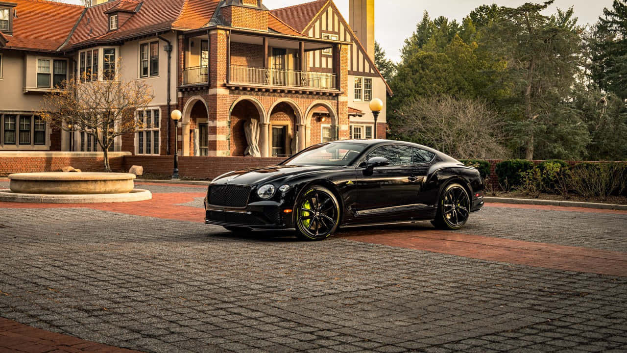 Luxurious Bentley Continental GT cruising on an open road Wallpaper