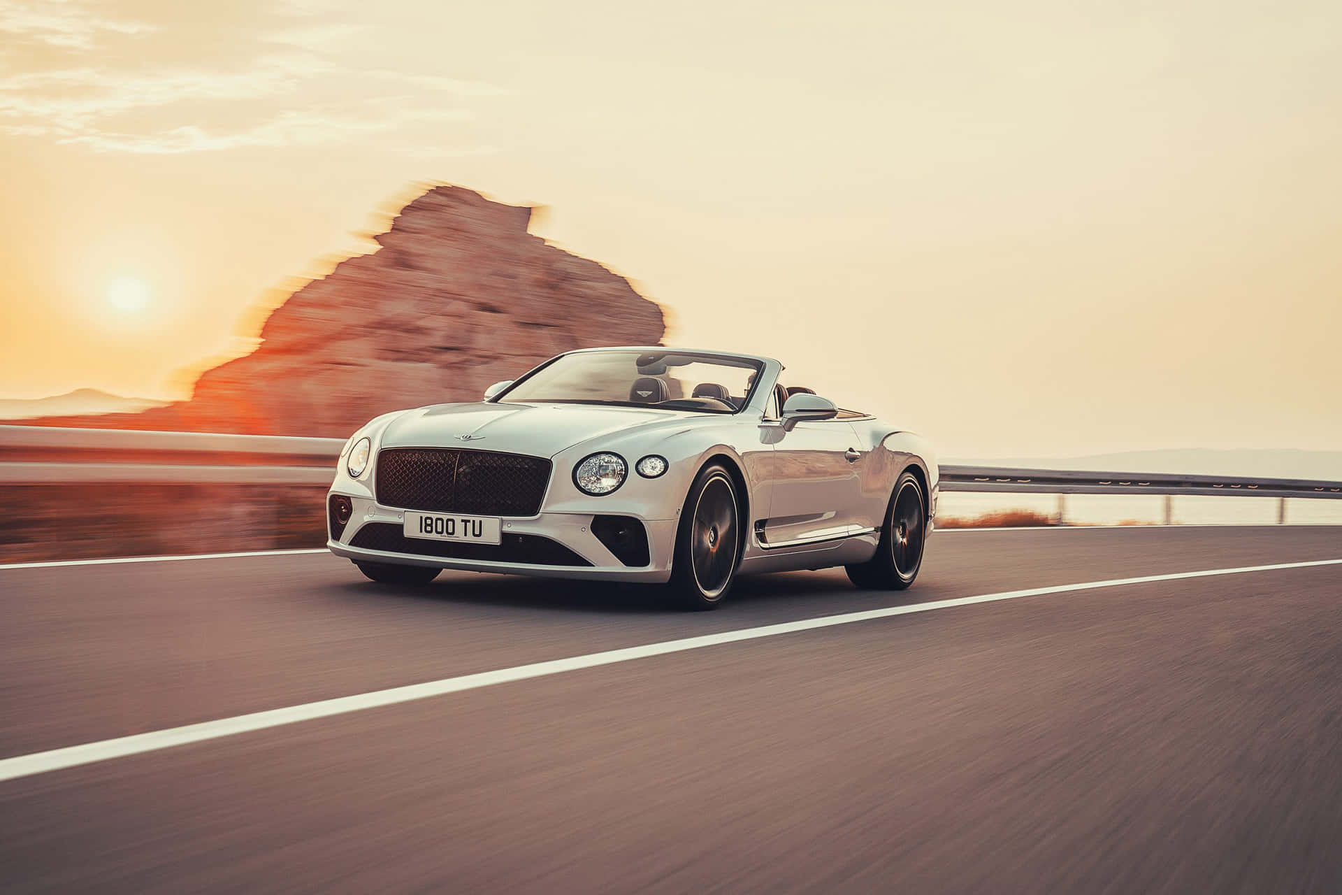 Elegant Bentley Continental GT Convertible cruising on the road Wallpaper