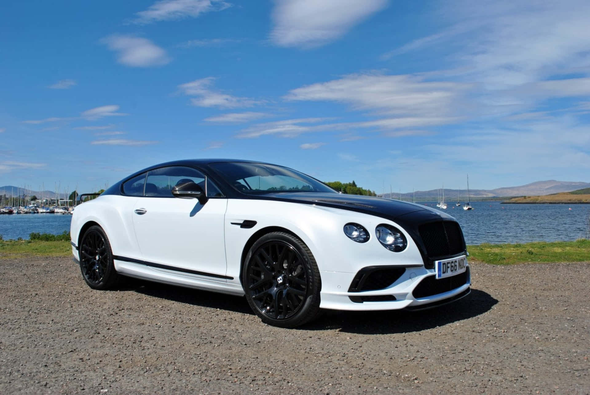 Sleek Bentley Continental Supersports on Scenic Roadway Wallpaper