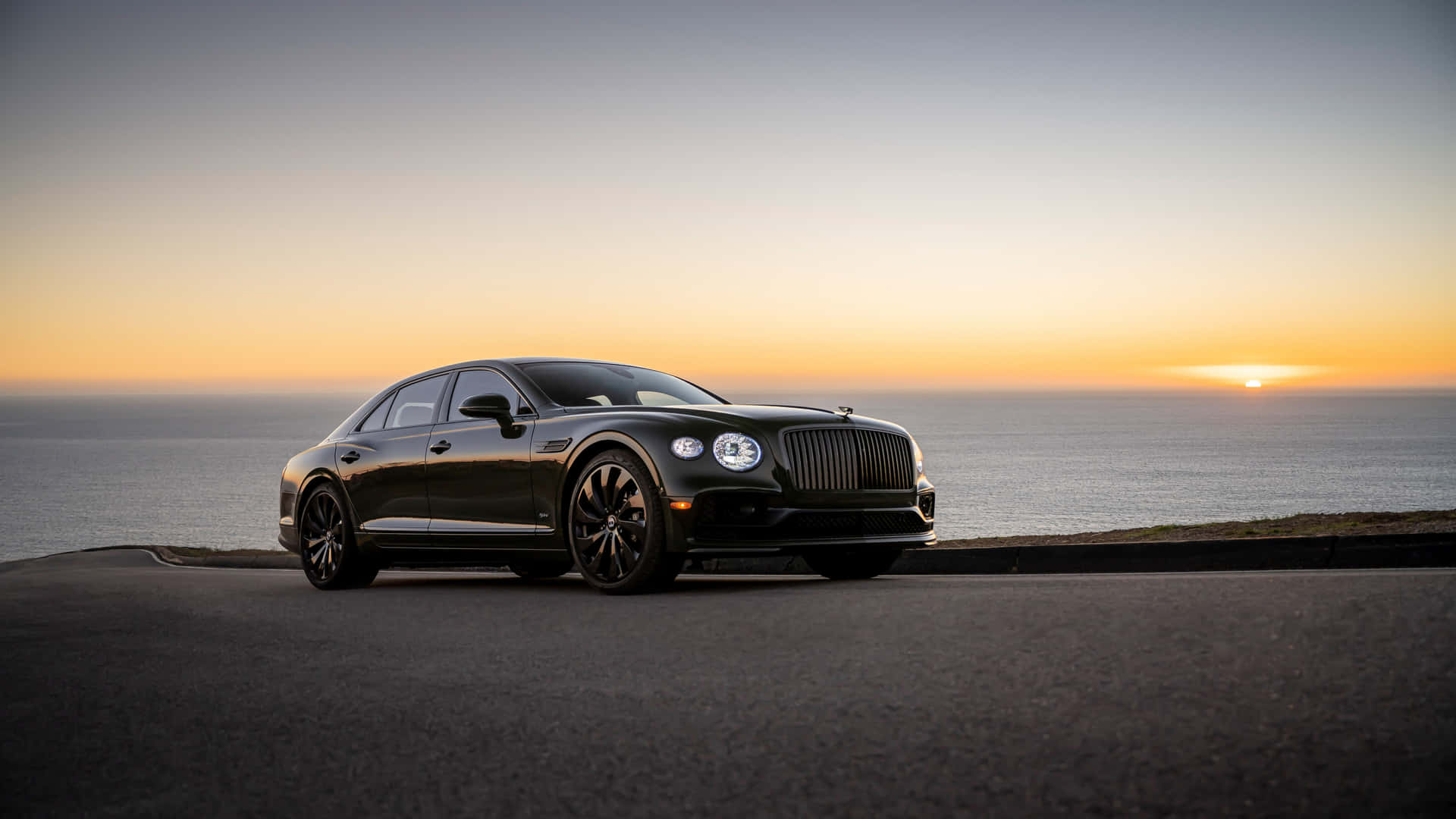 Caption: The Elegant and Powerful Bentley Flying Spur Cruising on the Open Road Wallpaper