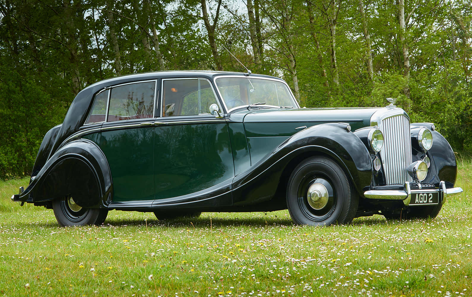Caption: A vintage Bentley Mark VI shines radiantly in a luxurious setting. Wallpaper