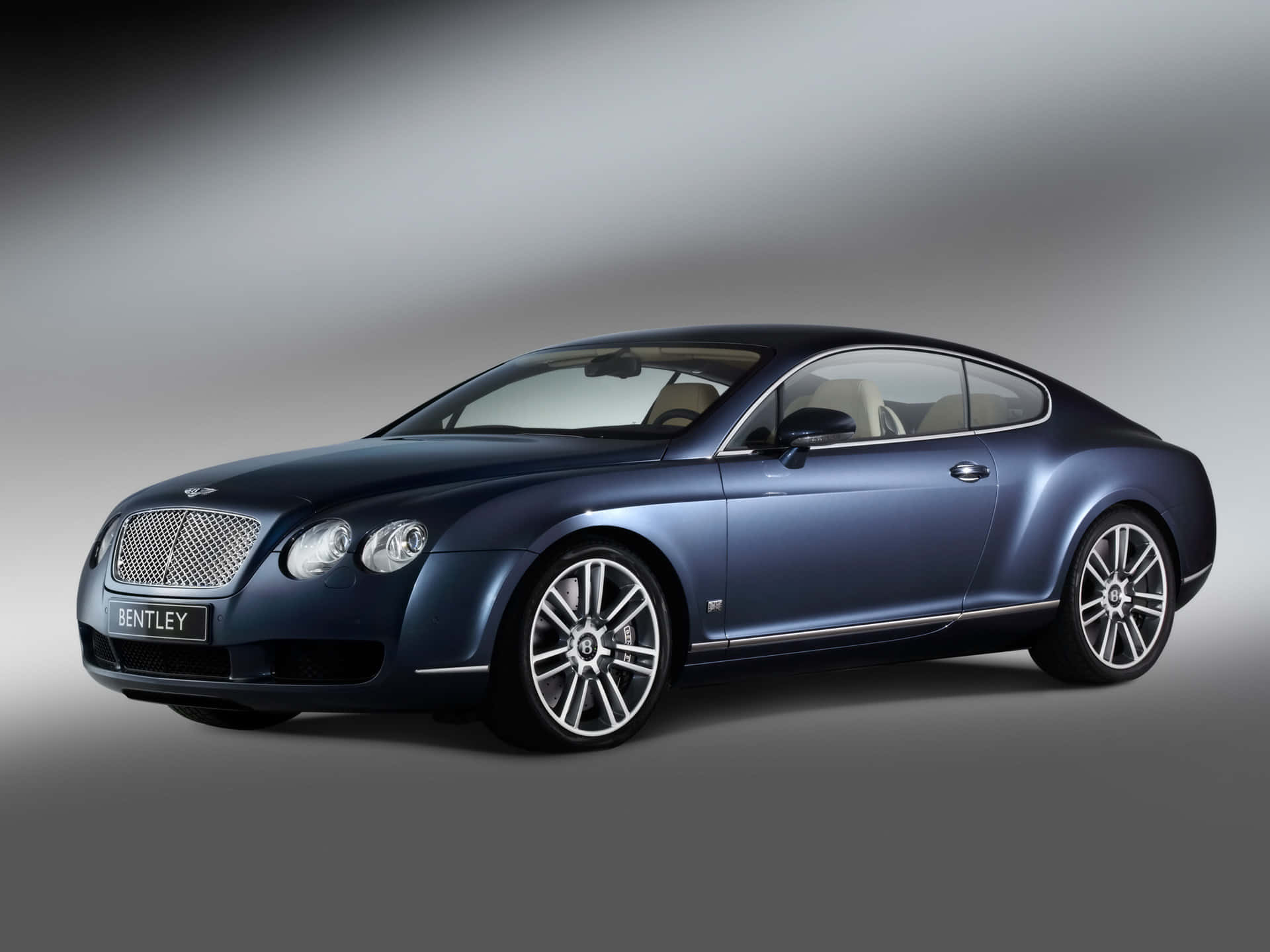 A sleek Bentley Continental GT glimmering under the spotlight