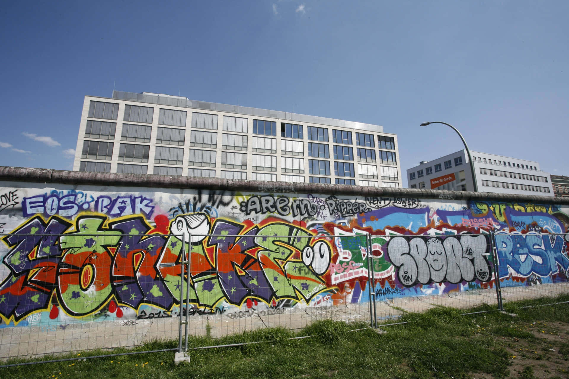 Berlin Wall With Graffiti Against Buildings Picture