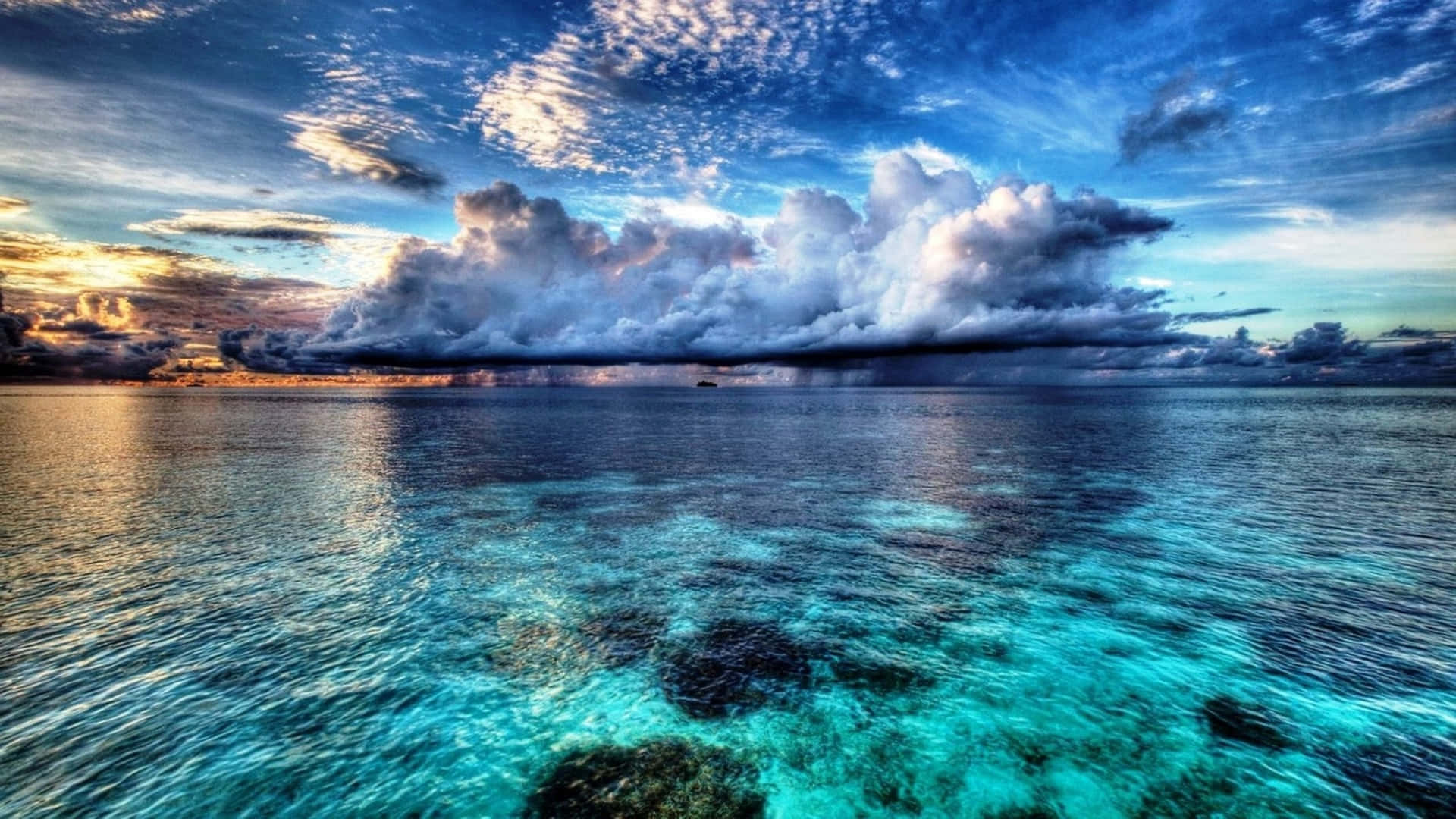 a cloud over the ocean with blue water
