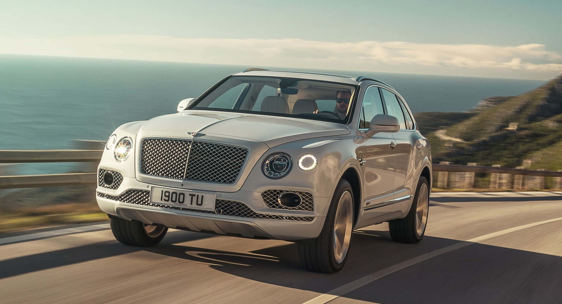 The Bentley Bentayga Is Driving Down A Road