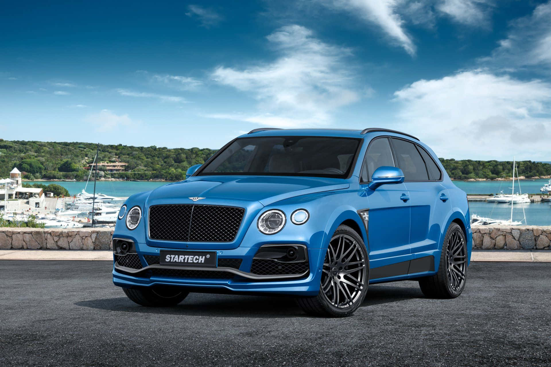 Bentley Bentayga - A Blue Suv Parked In Front Of A Marina