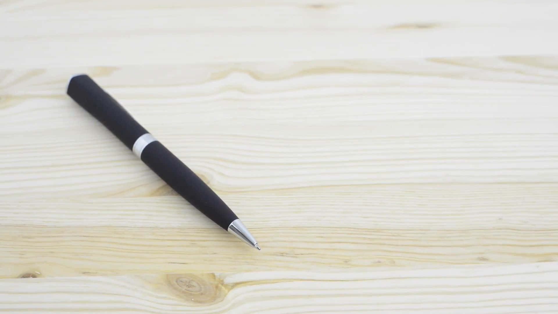 A Black Pen On A Wooden Surface