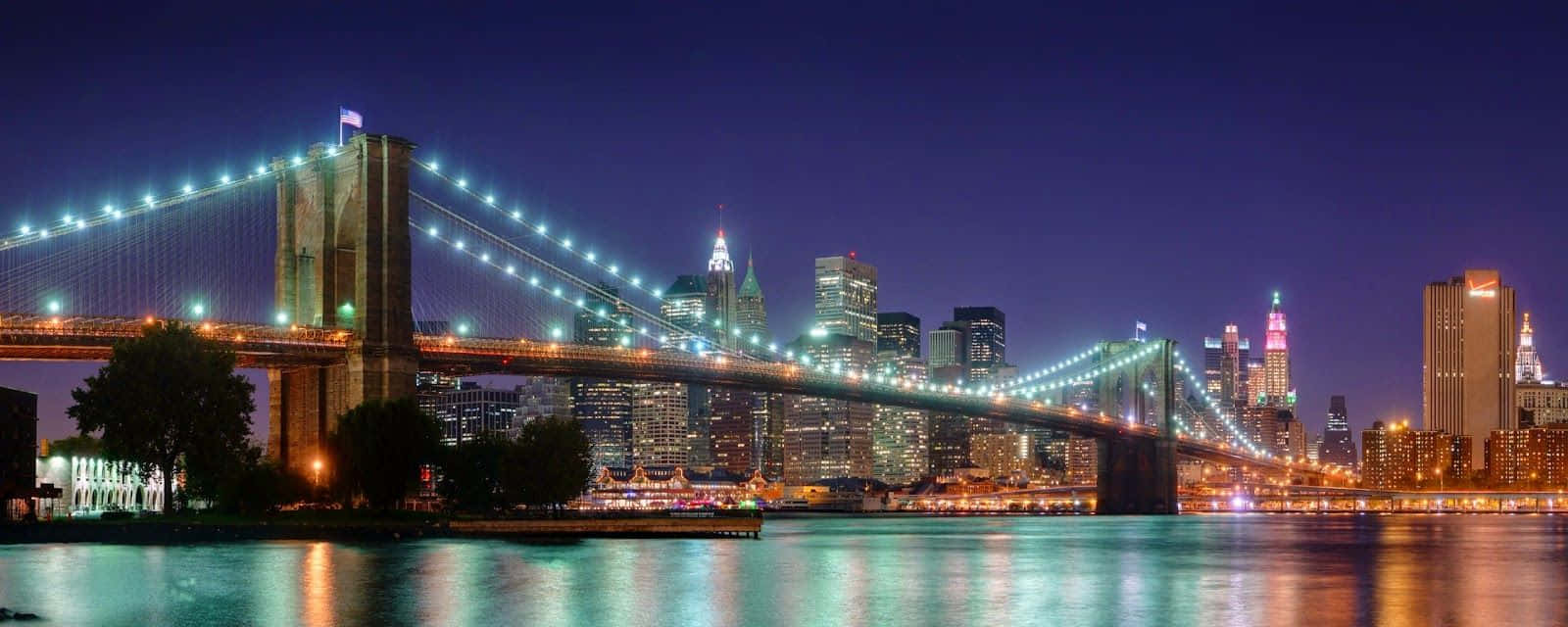 Brooklyn Bridge At Night With The City Lights Wallpaper