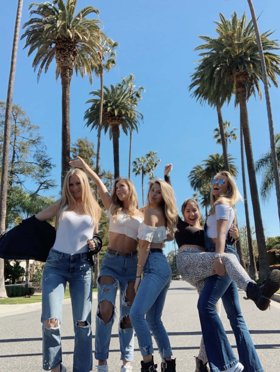 A Group Of Girls In Jeans And T-shirts Posing For A Photo Wallpaper