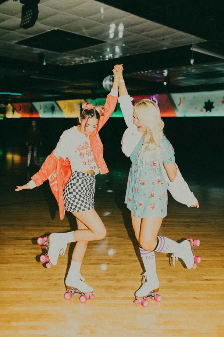 Two Women Rollerblading In A Roller Rink Wallpaper
