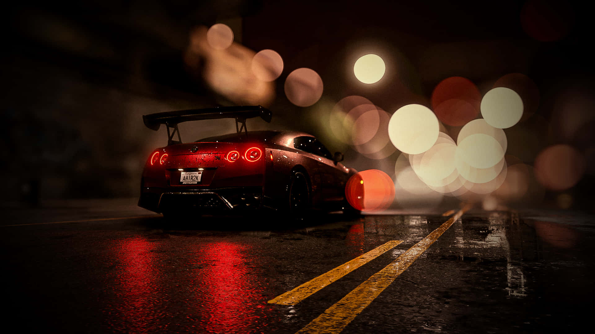 En rød bil kører ned ad gaden om natten Wallpaper