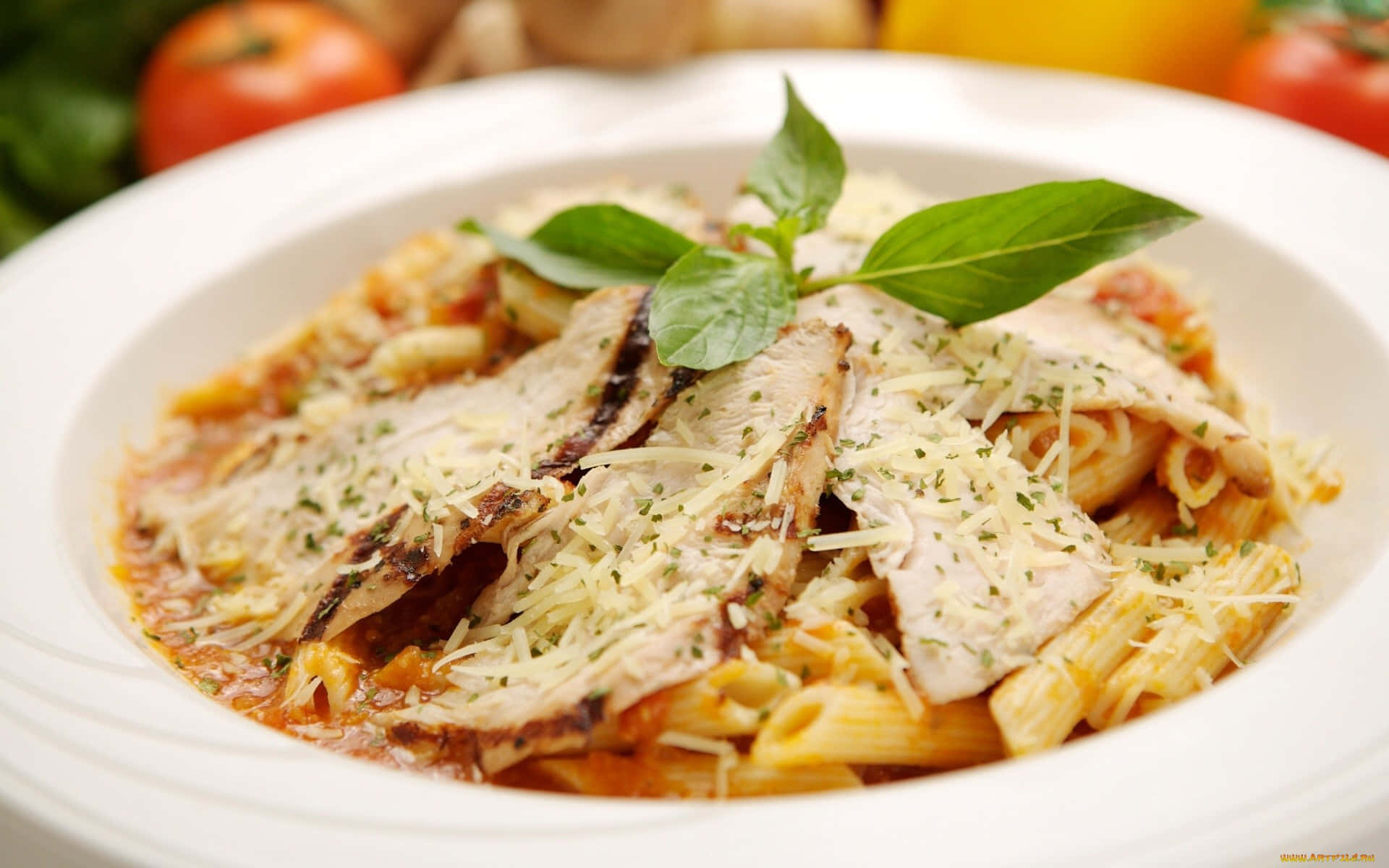 A White Plate With Pasta And Chicken In It