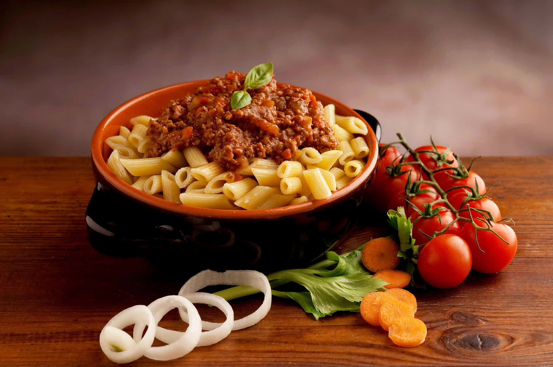 A Bowl Of Pasta With Meat And Vegetables