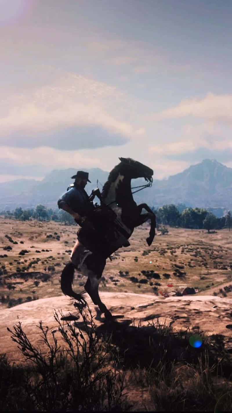 Migliorsfondo Di Red Dead Redemption 2 Con Un Cowboy Che Fa Stare In Piedi Il Suo Cavallo