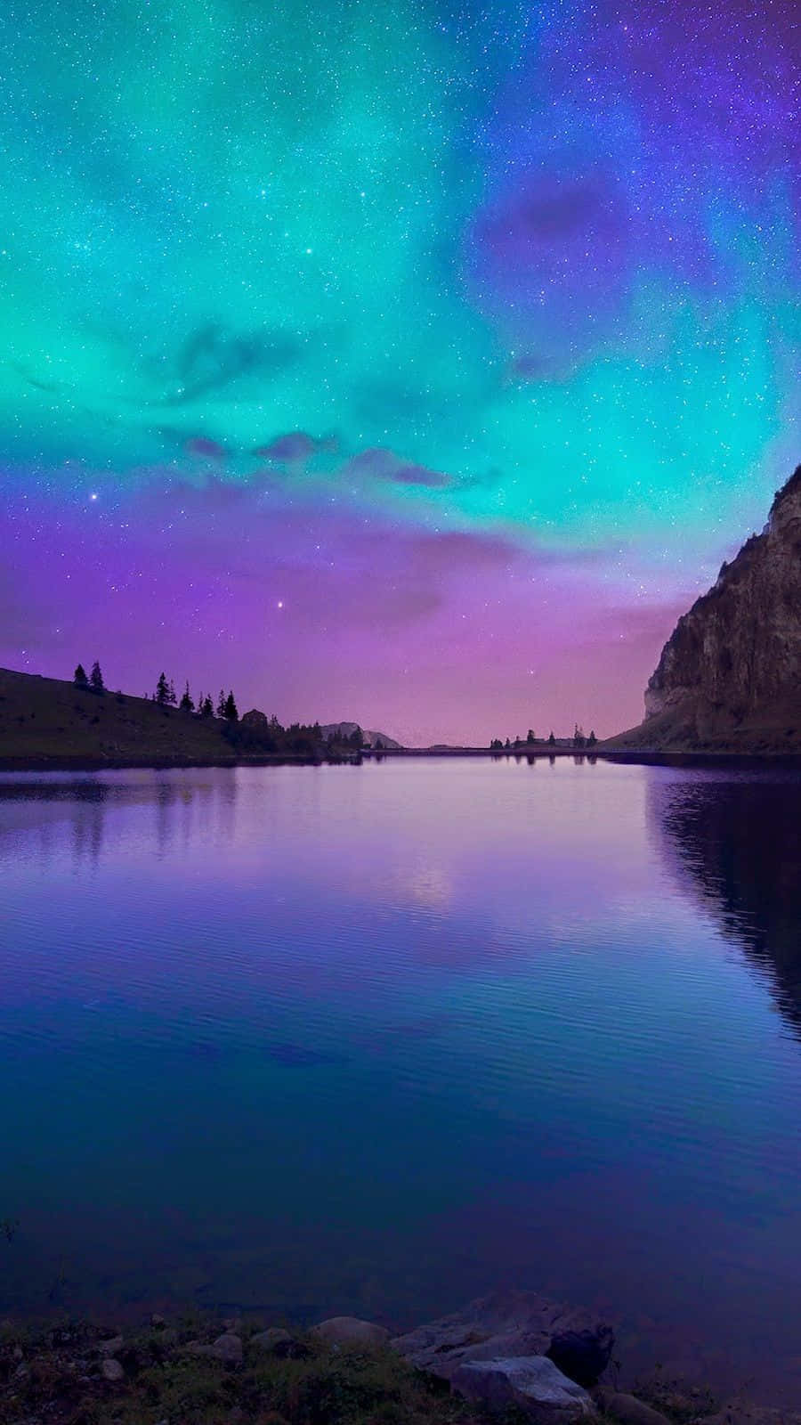 Den aurora bore over en sø med bjerge i baggrunden Wallpaper