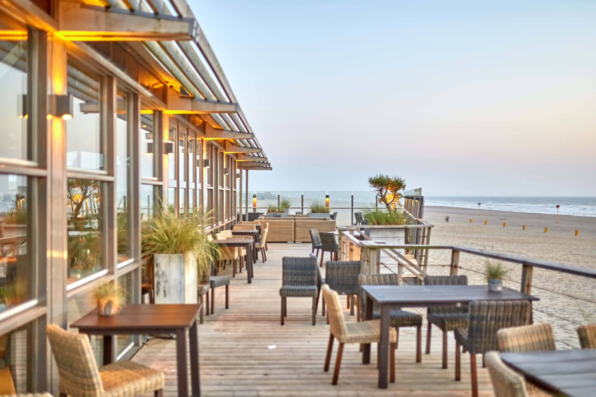 A Restaurant With Tables And Chairs On The Beach