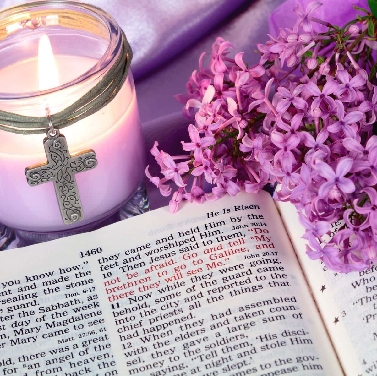 A Candle And A Bible With Lilac Flowers