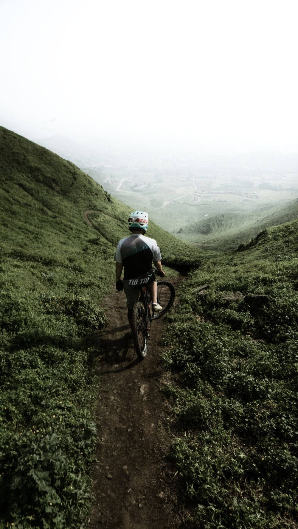Unuomo Che Cavalca Una Mountain Bike Su Una Collina Verde Sfondo