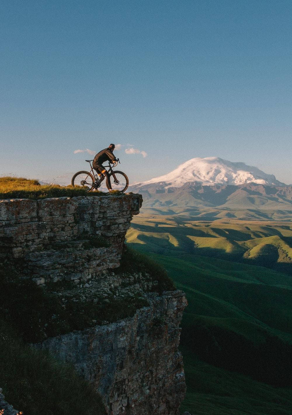 Bike Ride On Cliff Background