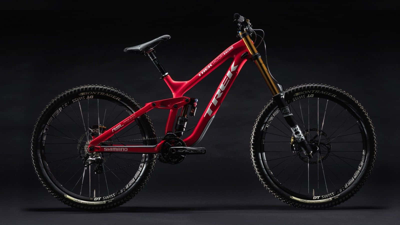 A Red Mountain Bike Is Shown Against A Black Background