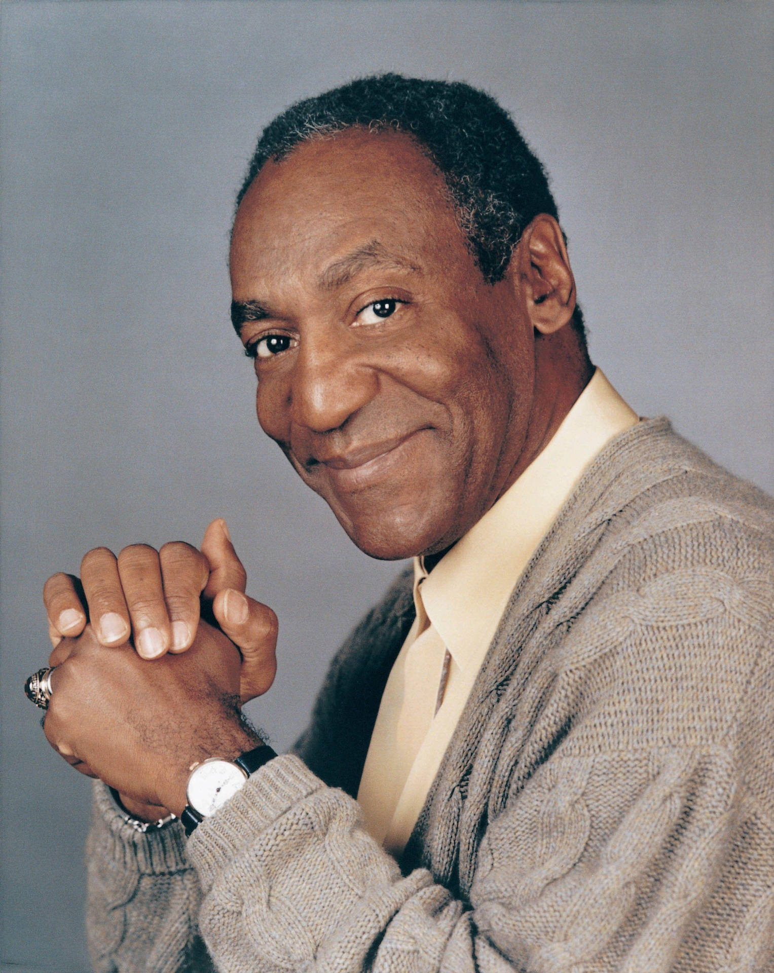 A Reflective Bill Cosby Clasping His Hands Wallpaper