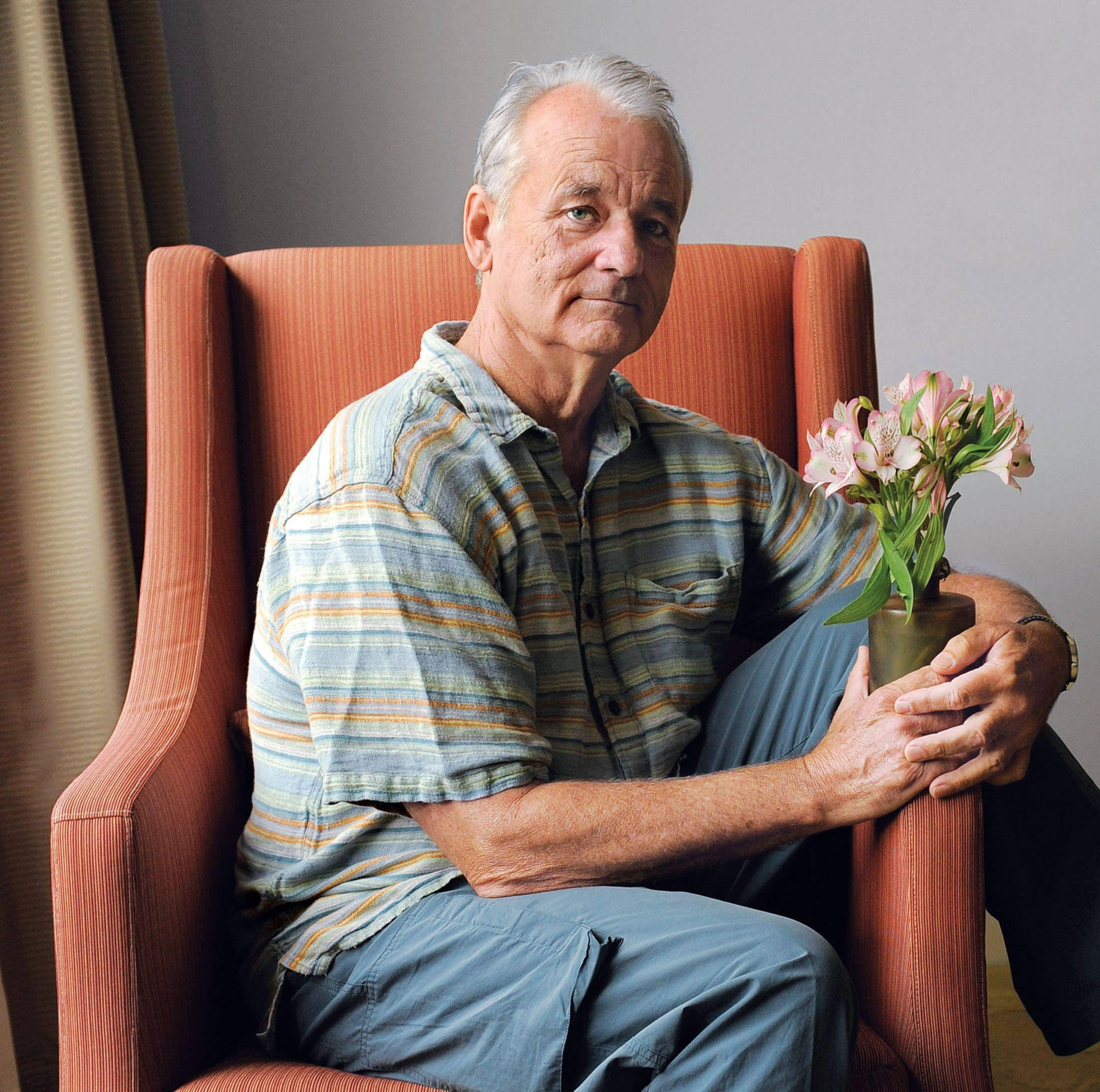 Billmurray Sitzt Auf Einem Stuhl Vor Blumen Im Hotel. Wallpaper