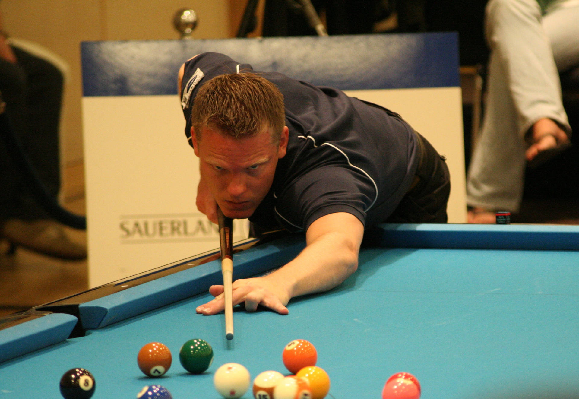 Billiards Athlete With Pool Stick On Blue Pool Table. Wallpaper