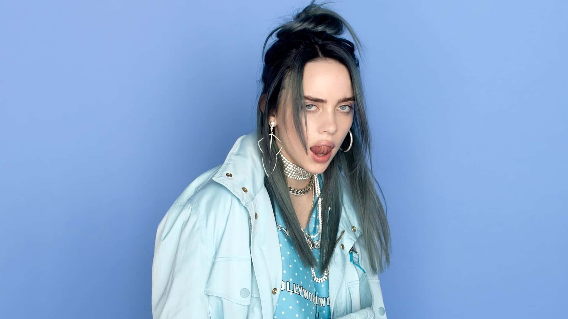 Billie Eilish with her laptop in a cozy home setting. Wallpaper