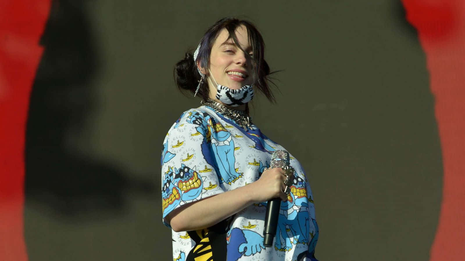 Billie Eilish confidently turns on her laptop, ready to create her unique style of music. Wallpaper