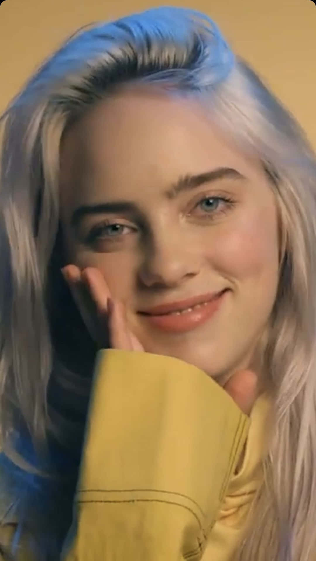 Billie Eilish with a smile on her face Wallpaper