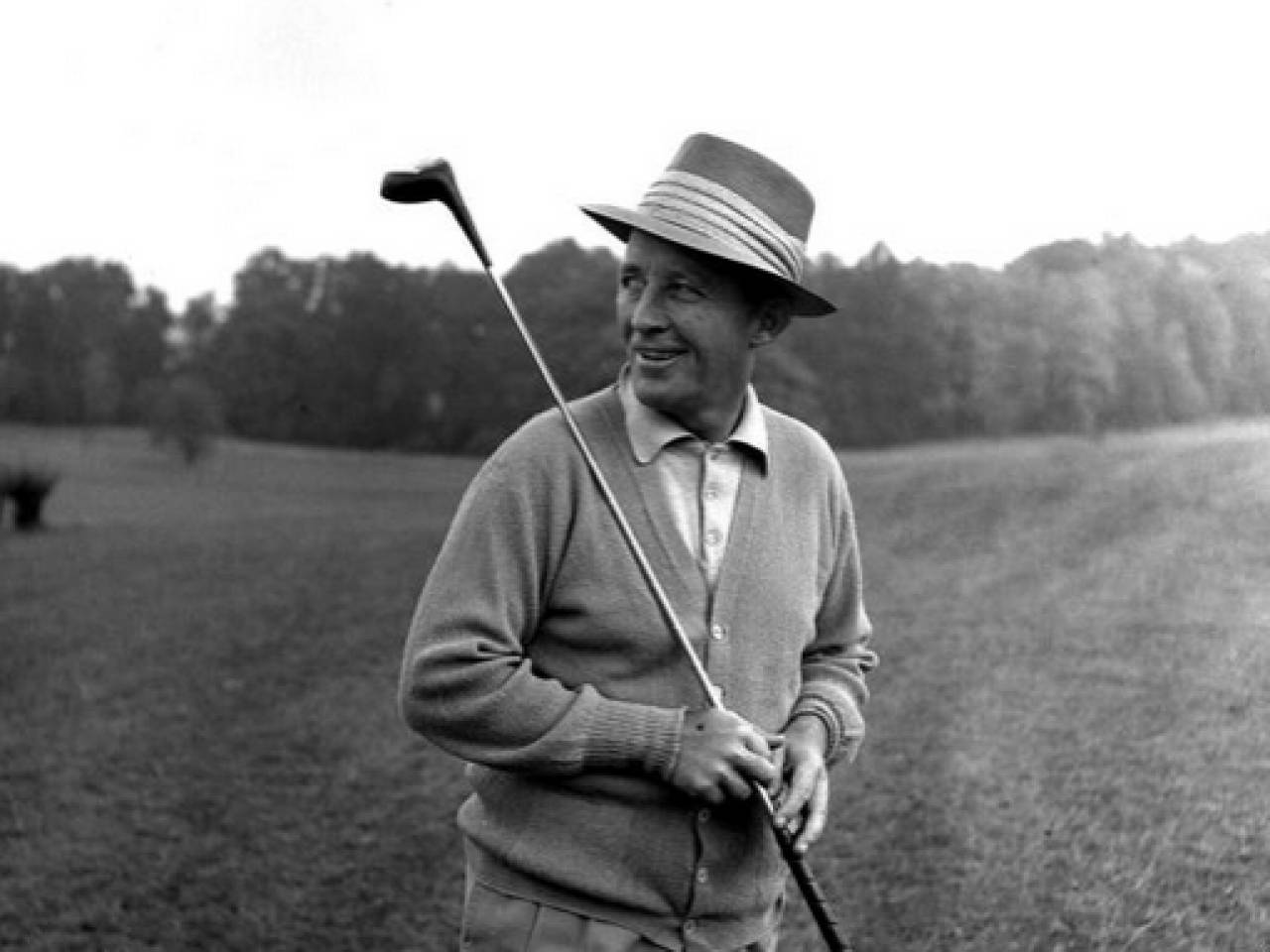 Bing Crosby holder en golfstav på en blå karikeret baggrund. Wallpaper