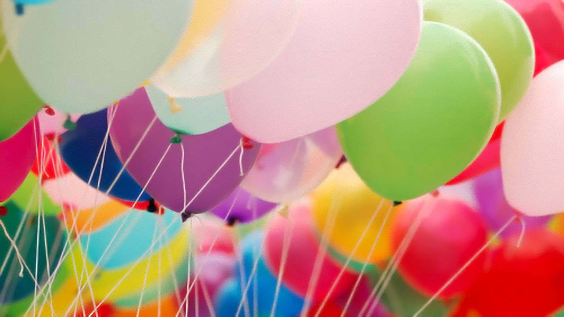 Geburtstagsballons,die Mit Schnüren In Der Luft Schweben.