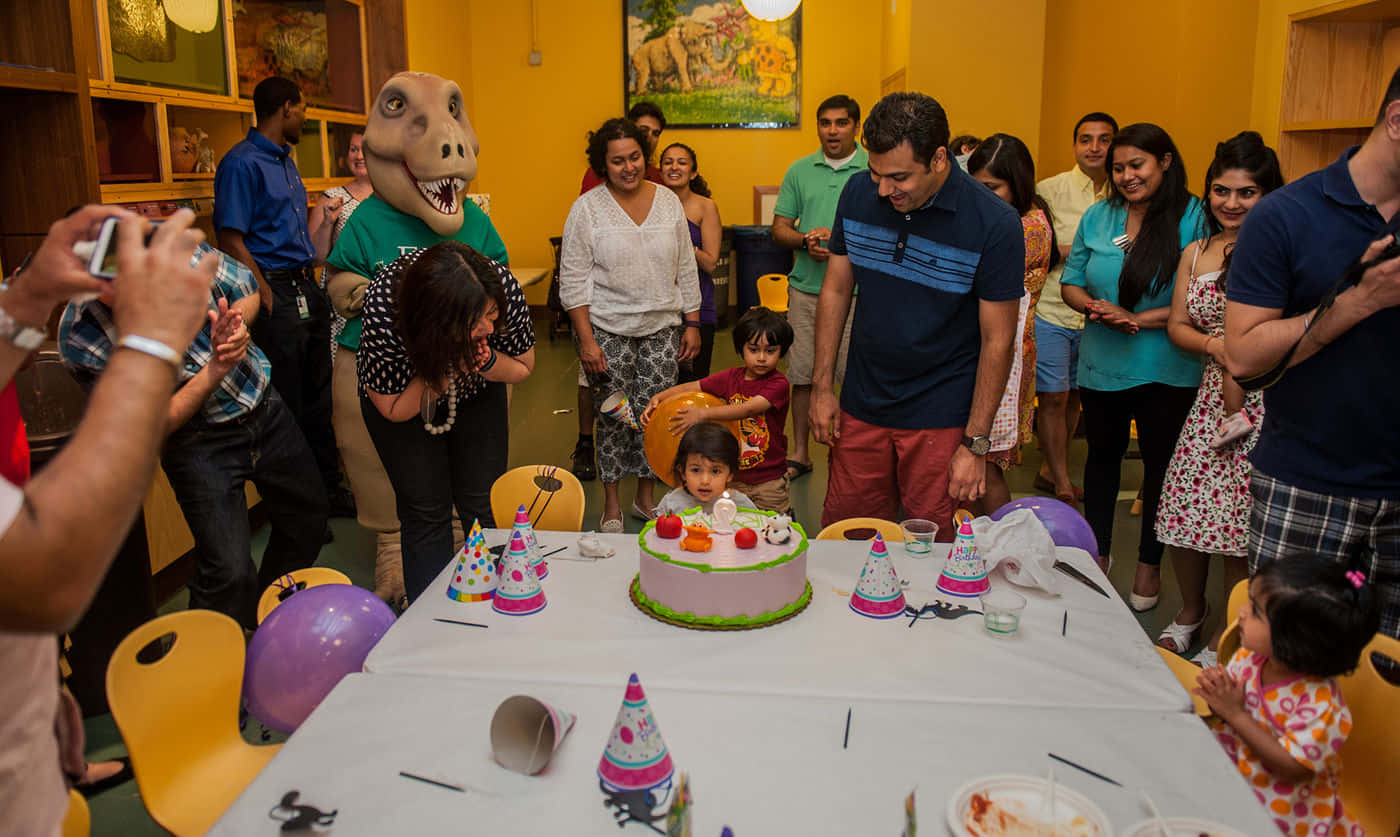 Birthday Party Crowd Gathers Around Birthday Cake Picture
