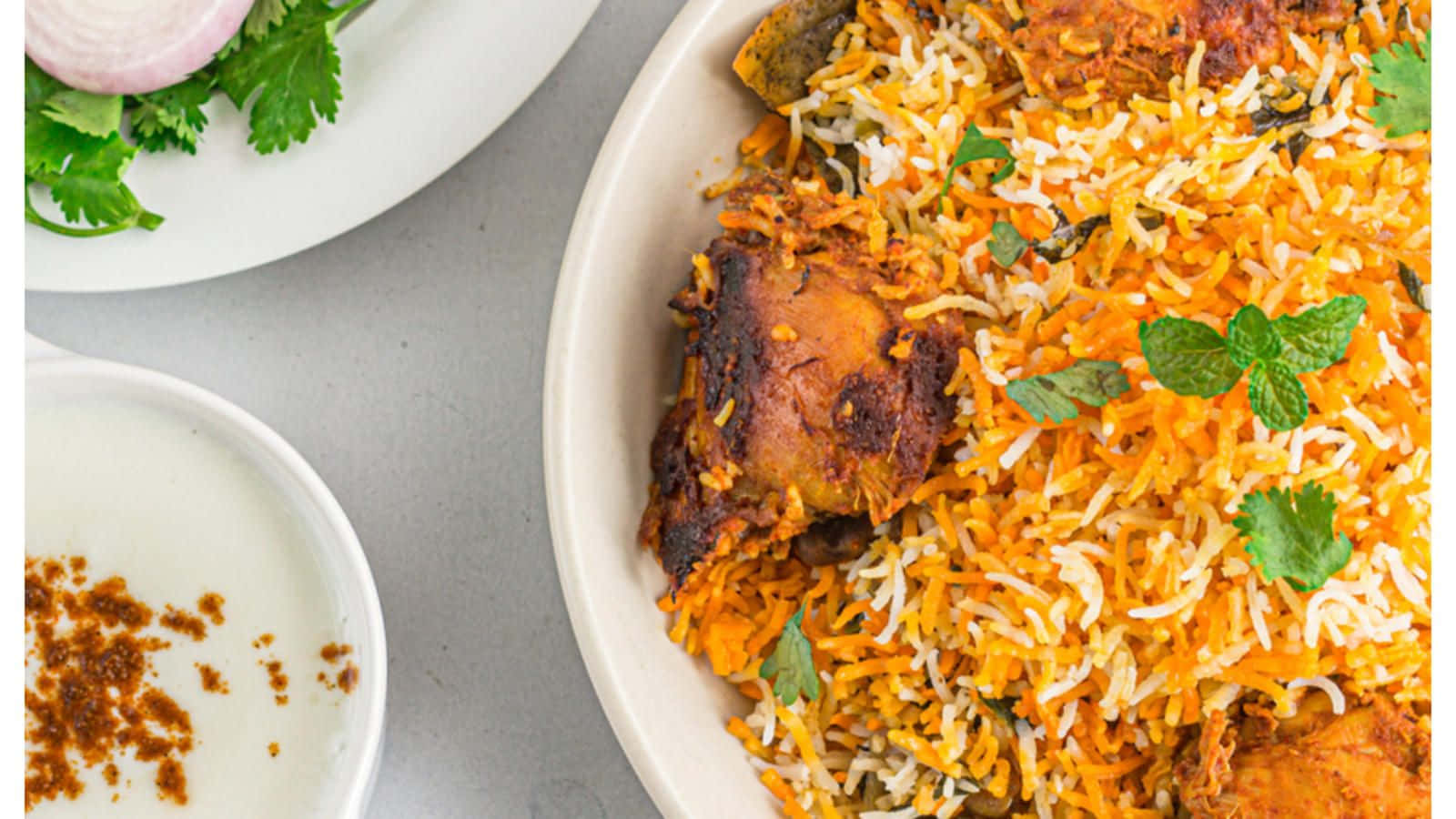Delicious and Flavorful Biryani Served in a Bowl with Raita and Salad