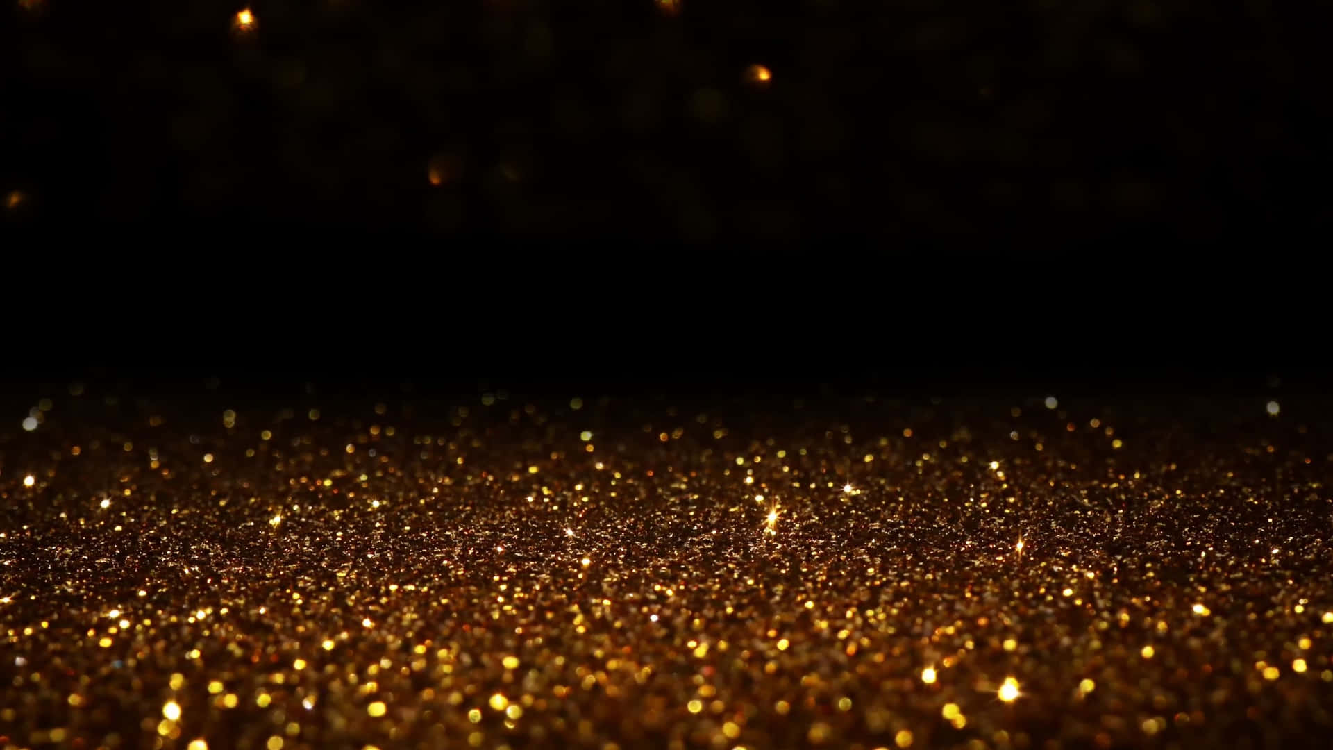 Glowing Black And Gold Glitter Particles Wallpaper