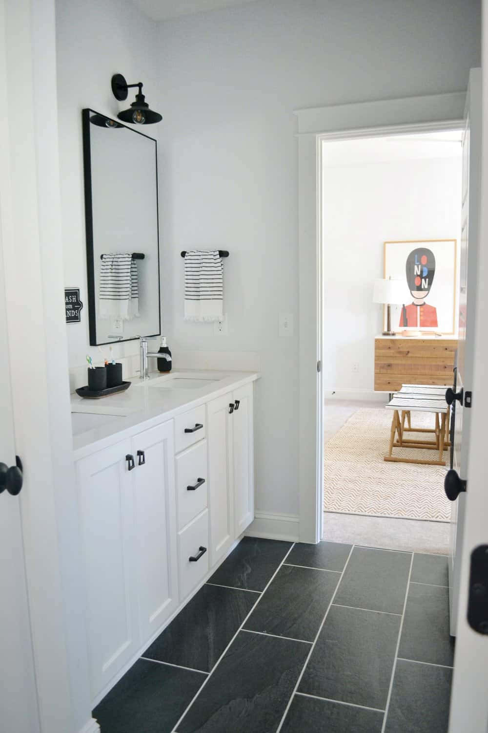 A Bathroom With White Tile And Black Tile