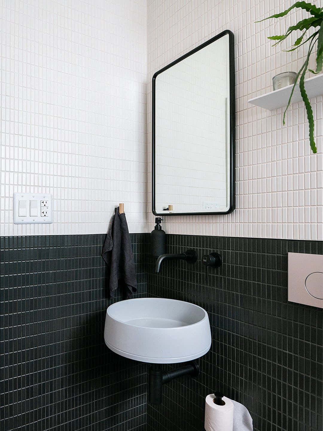 A Bathroom With Black Tile And A Sink