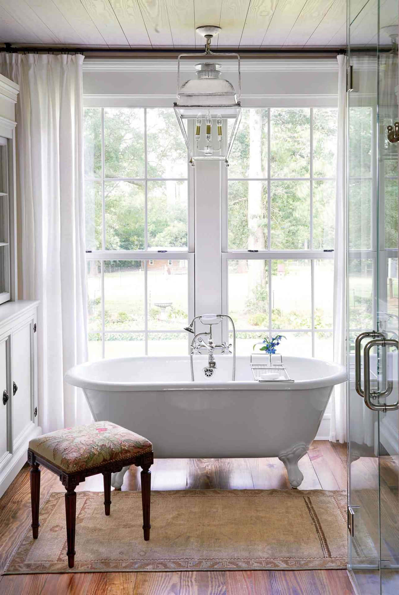A White Bathroom With A Large Tub And A Stool