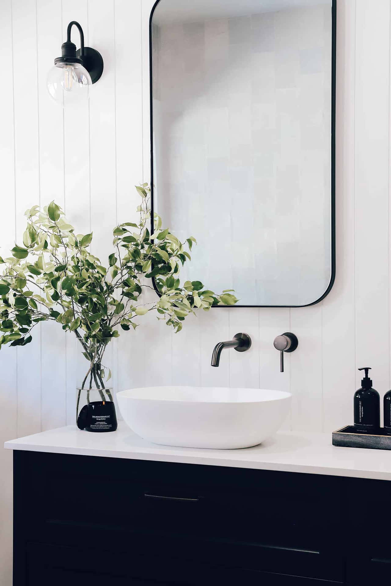 A Bathroom With A Black Sink And Mirror